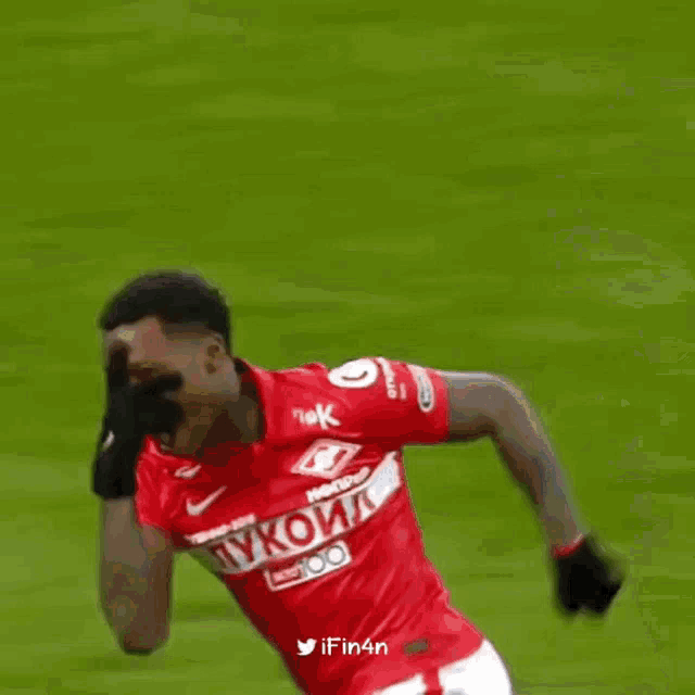 a man in a red shirt with the number 9 on it is laying on the grass .