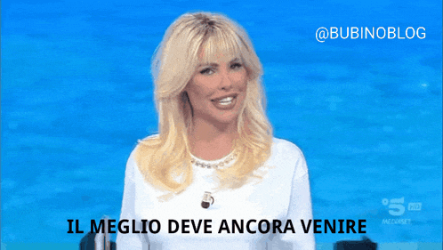 a woman wearing black gloves is smiling and says il meglio deve ancora venire