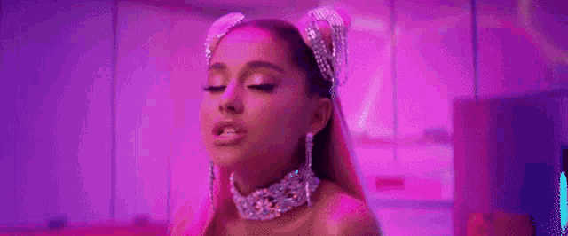 ariana grande is wearing a choker and earrings in a pink room with purple lights .