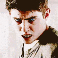 a young man with blue eyes is looking at the camera with a very angry look on his face .