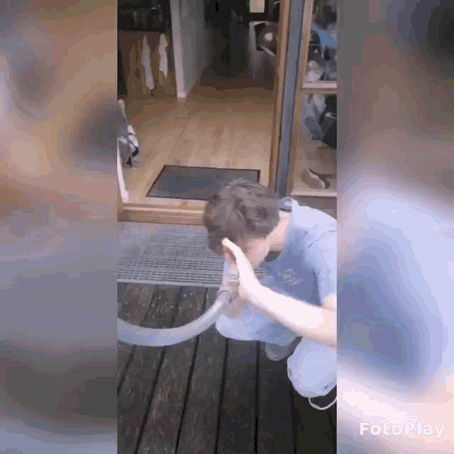 a man playing with a hose on a wooden deck with the word fotoplay at the bottom
