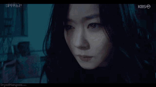 a close up of a woman 's face with kbs written on the bottom right