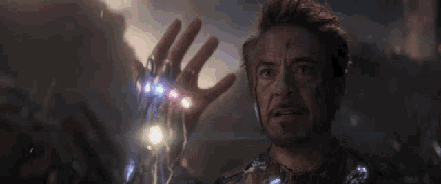 iron man is holding the infinity gauntlet in his hand in avengers : age of ultron .