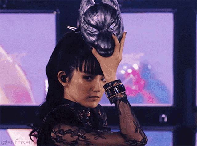 a woman is holding a wolf mask on her head and the watermark at the bottom reads @atnloser