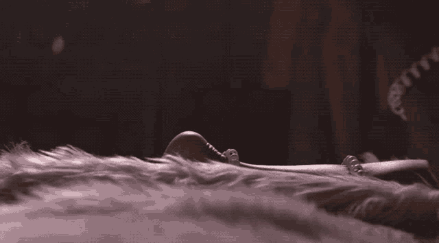 a woman is laying on a bed wearing a necklace