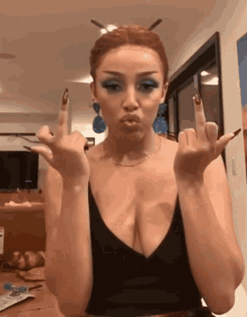 a woman in a black top is giving the middle finger .