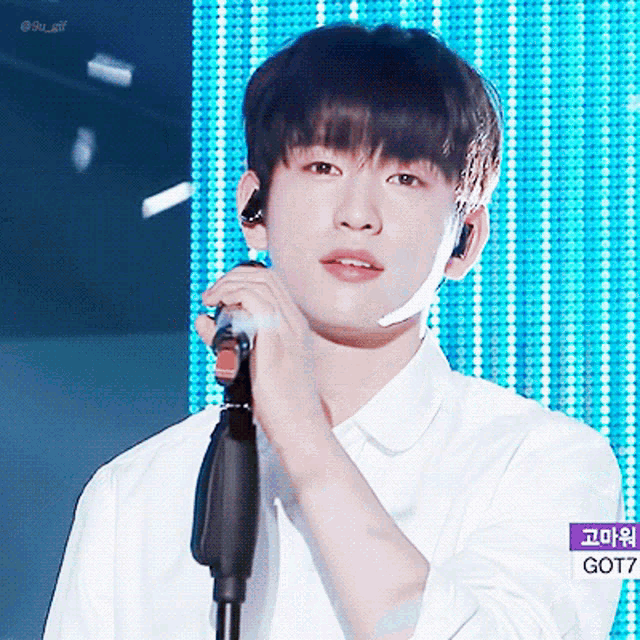a young man singing into a microphone with the word got7 on the bottom