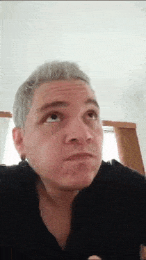 a man with gray hair is making a funny face and looking up at the camera .