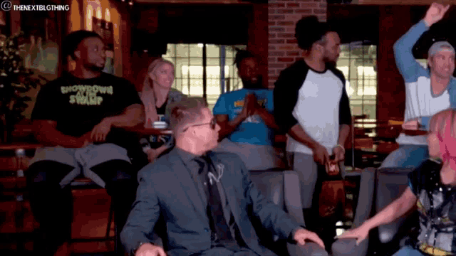 a group of people are sitting at a bar and one of them is wearing a shirt that says showdown swamp