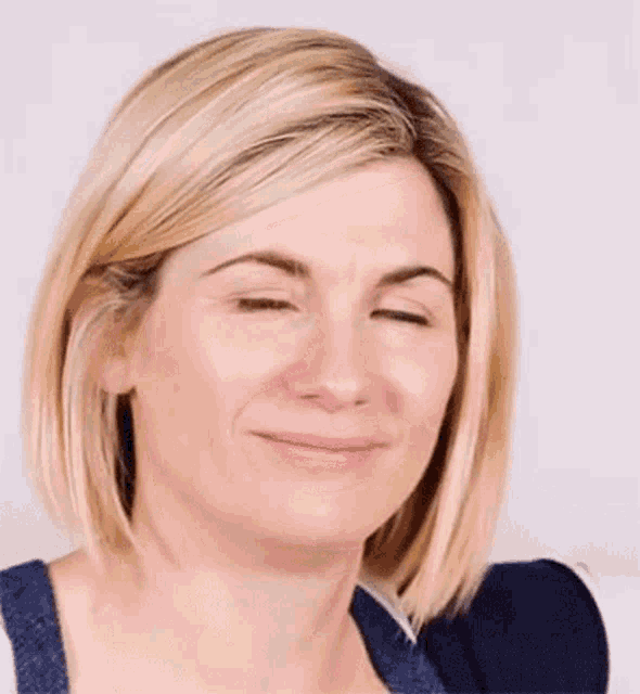 a close up of a woman 's face with blonde hair and a smile .