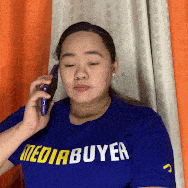 a woman wearing a blue shirt that says mediabuyer on it
