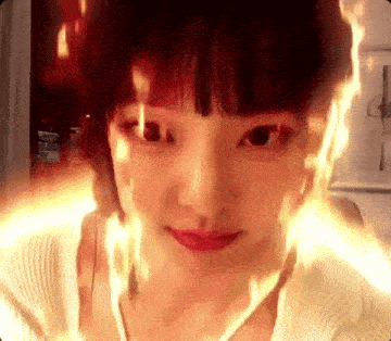 a close up of a woman 's face with flames coming out of it