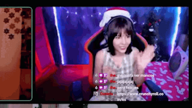 a girl wearing headphones and a santa hat is sitting in a gaming chair
