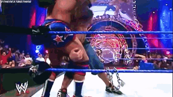 two wrestlers are fighting in a wrestling ring with chains around their legs .