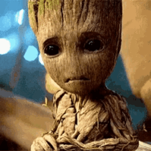 a baby groot from the movie guardians of the galaxy is sitting on a table .