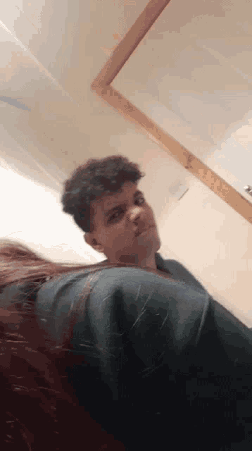 a man with curly hair is looking at the camera