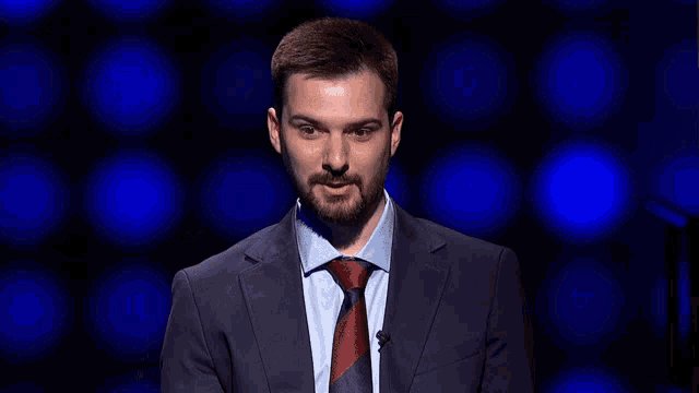 a man in a suit and tie points to something