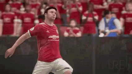 a soccer player in a red shirt is jumping in the air while playing a game .