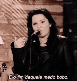 a woman singing into a microphone with the words eo fim daquele medo bobo