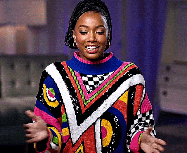 a woman wearing a colorful sweater with a blue turtleneck