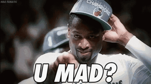 a man wearing a hat with the word u mad on it is looking at the camera .