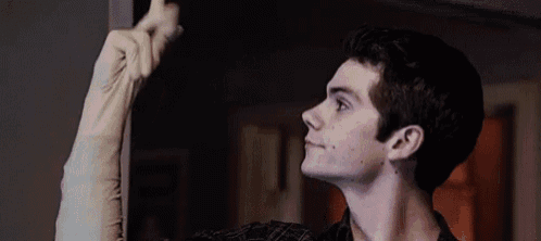 a young man is holding a pair of white gloves up in the air .