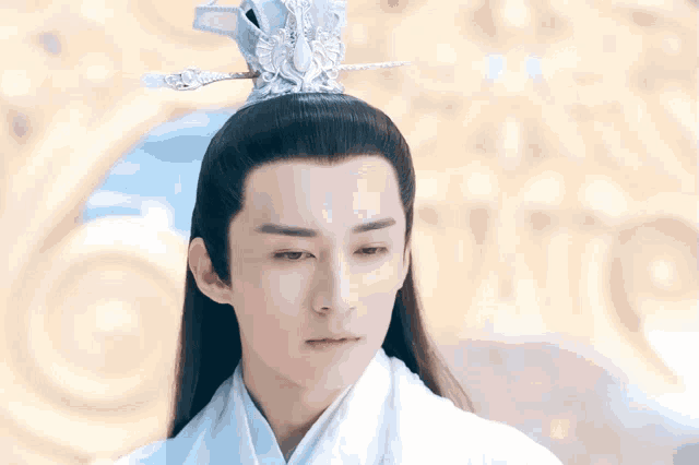 a man with a crown on his head is wearing a white shirt