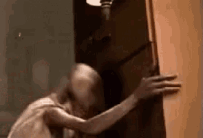 a ghost is standing in a doorway holding a door .