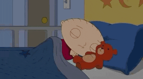 a cartoon character is sleeping in a bed with a teddy bear and a blanket .