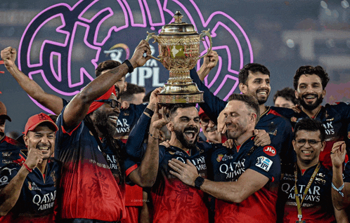 a group of men holding a trophy with qatar airways written on their shirts