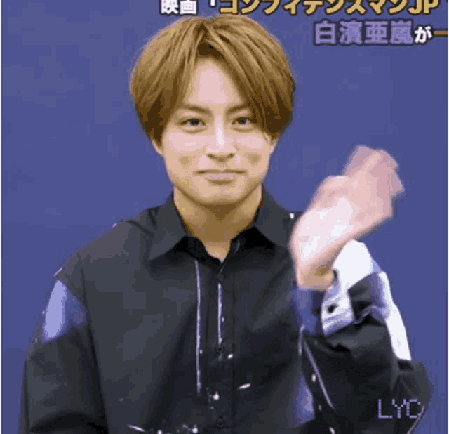 a man in a black shirt is holding a pink object in his hand ..