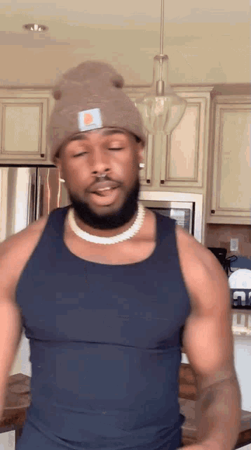 a man wearing a beanie and a tank top