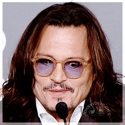 a close up of johnny depp 's face with glasses and a microphone