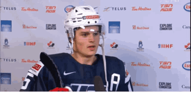 a hockey player is standing in front of a telus sign