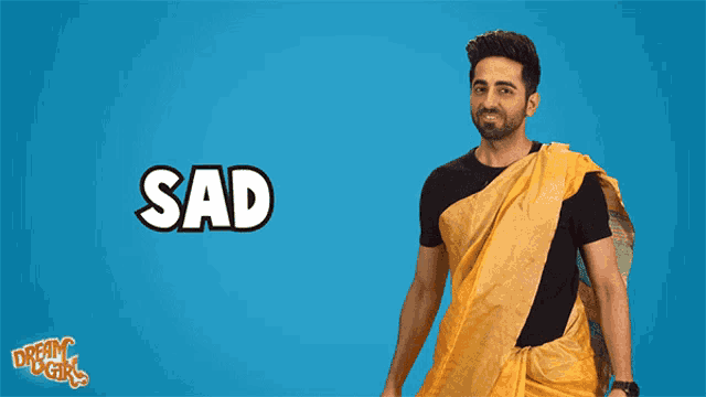 a man in a yellow saree is standing in front of the word sad