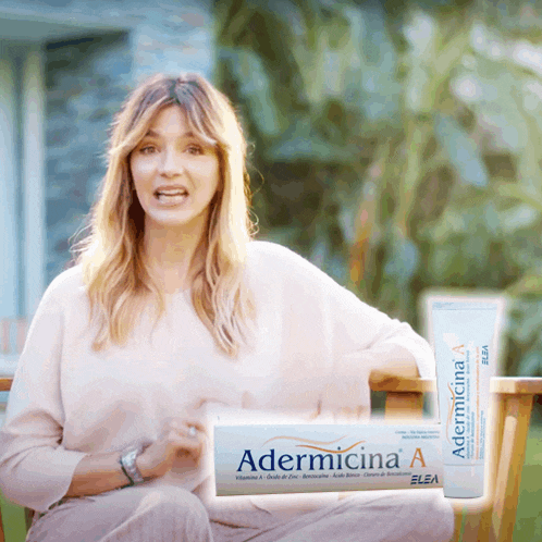 a woman sitting on a bench next to a tube of adermicina a