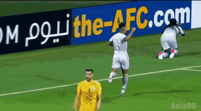 soccer players on a field with a sign that says the-afc.com