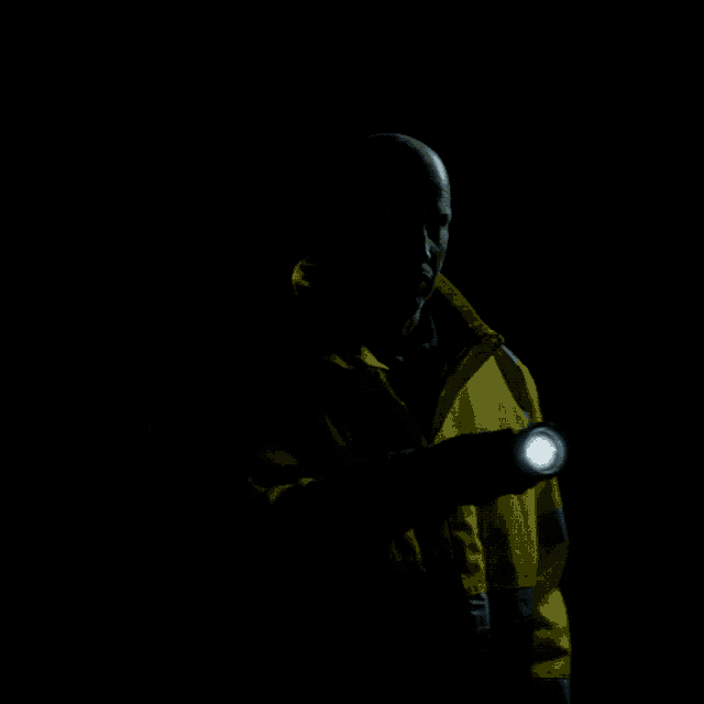 a man in a yellow jacket is holding a flashlight