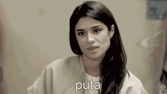 a woman in a jail cell is looking at the camera and saying `` puta '' .