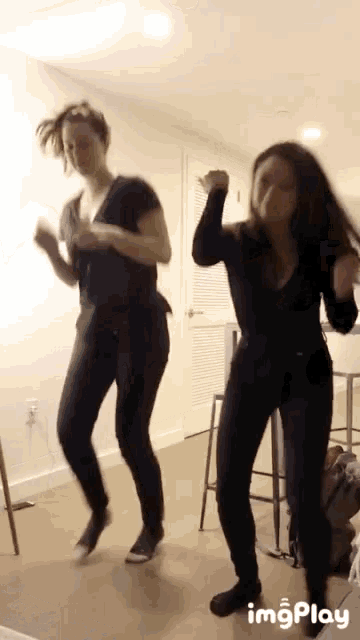 two women are dancing in a room with the words imgplay visible in the corner