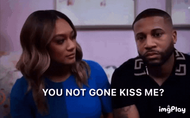 a man and a woman are sitting next to each other and the woman is saying you not gone kiss me