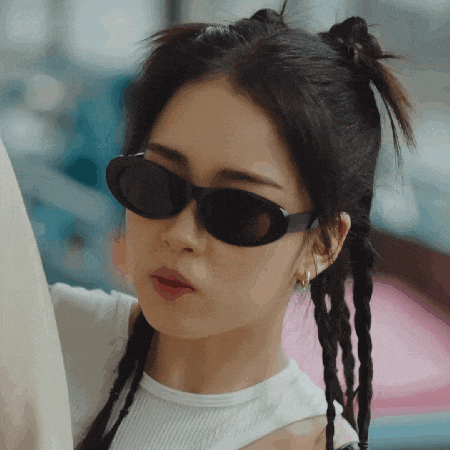 a close up of a woman wearing sunglasses and a white shirt