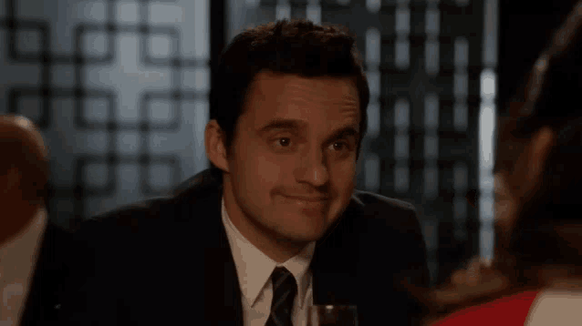 a man in a suit and tie with a glass of wine