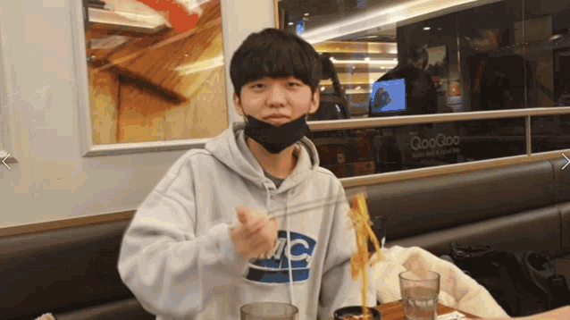 a man wearing a mask and a sweatshirt that says tc
