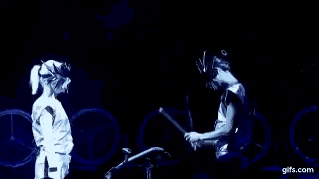 a man and a woman are standing next to each other in a dark room .