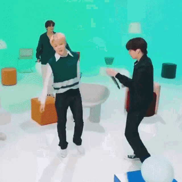 a group of men are dancing in a room with a blue background .