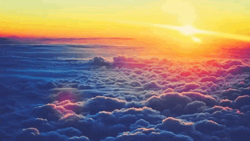 the sun is setting over the clouds