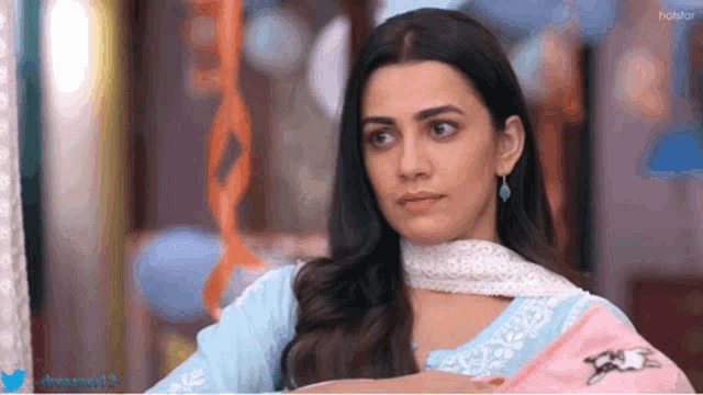 a woman in a blue and white dress is looking at something