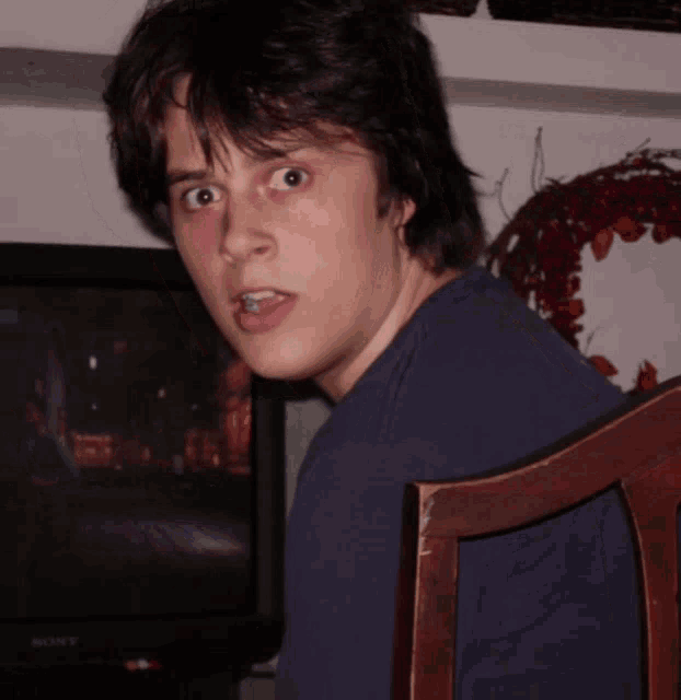 a man sitting in front of a sony tv