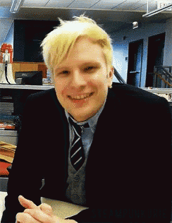 a man wearing a suit and tie is smiling for the camera